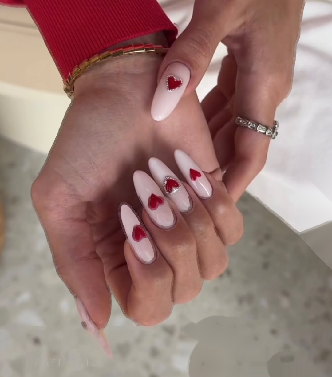 Długi migdałowy manicure mleczny róż z czerwonymi serduszkami Gelish